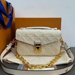 This is the Louis Vuitton Pochette Métis East West handbag, made of cream-colore